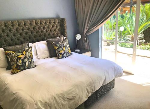 a bedroom with a large bed with a large window at Lindekroon Guest House in Polokwane