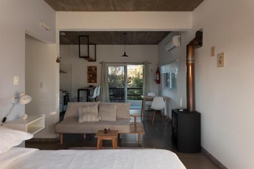 a bedroom with a bed and a living room at Complejo il Pensiero Punta del Diablo in Punta Del Diablo