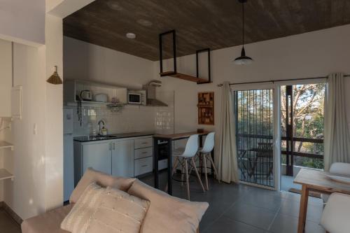 a kitchen and living room with a couch and a table at Complejo il Pensiero Punta del Diablo in Punta Del Diablo