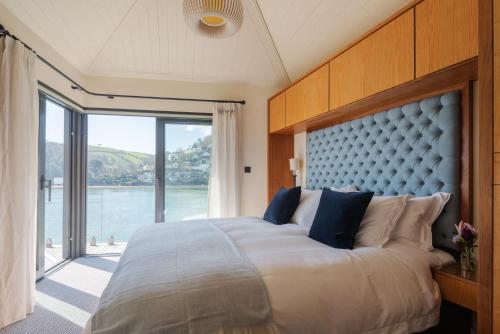 a bedroom with a large bed with a large window at The Edge in Dartmouth