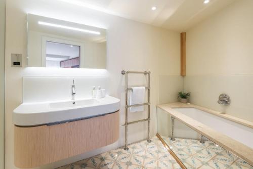 a bathroom with a sink and a bath tub at The Edge in Dartmouth