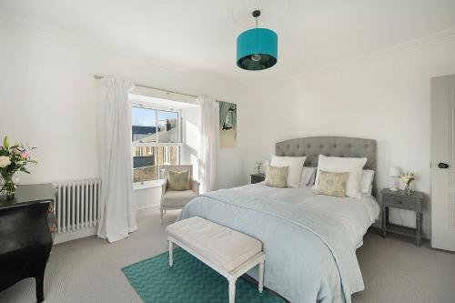 um quarto com uma cama, uma cadeira e uma janela em The Lodge em Strete