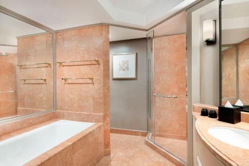 a bathroom with a tub and a shower and a sink at Sheraton Imperial Kuala Lumpur Hotel in Kuala Lumpur