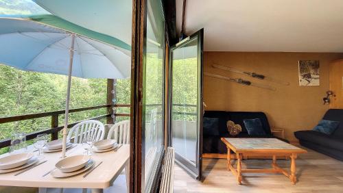 - une salle à manger avec une table et un parasol dans l'établissement Relais S18, à Saint-Jean-dʼAulps