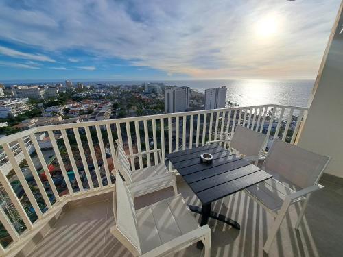 een balkon met een tafel en stoelen en de oceaan bij Panoramic Floor - Las Americas in Playa de las Americas