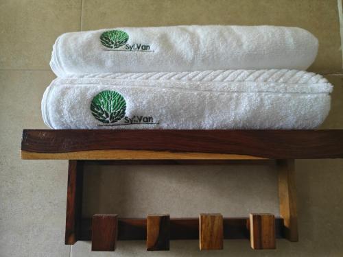 two towels sitting on top of a wooden shelf at SylVan Resort in Wayanad