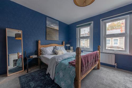 a bedroom with blue walls and a bed and a mirror at Large 5 bed 2 bath House - Free Parking - Reading Cent - Perfect for long contractor stays in Reading