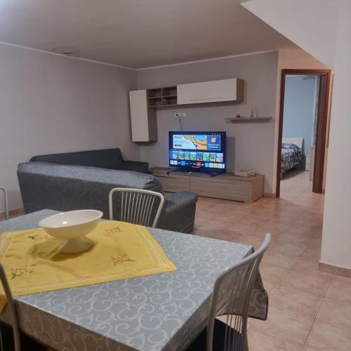 a living room with a table and a couch at Appartamento con Giardino, a 10 minuti dal Mare "PE" in Spoltore