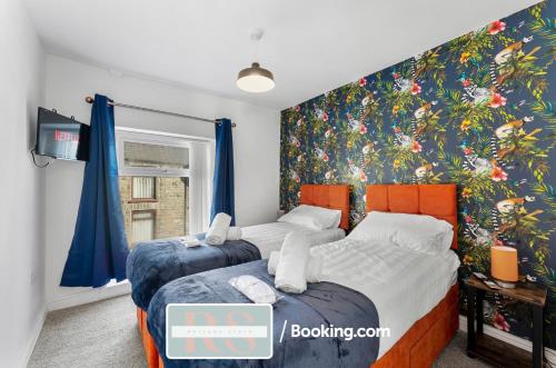 2 camas num quarto com um mural de parede floral em Contractors Accommodation South Wales By Rutland Stays Short Lets & Serviced Accommodation Pentre em Treorky