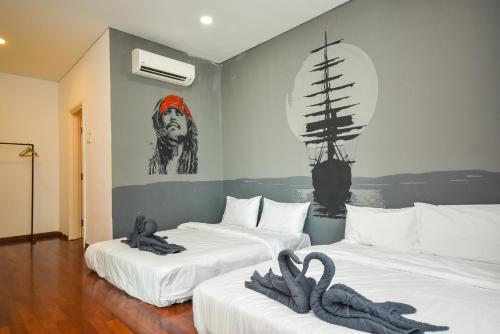two beds in a room with two swans on them at 1Medini Theme Suite by Nest Home【LEGOLAND】 in Nusajaya