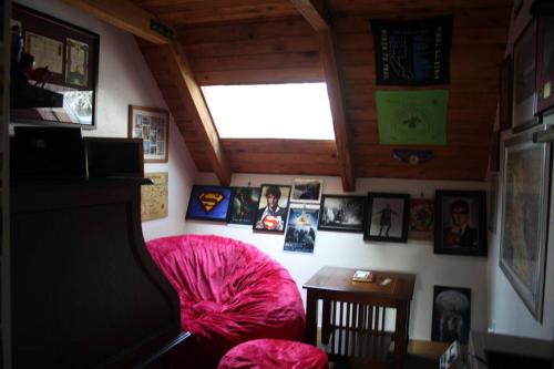 a room with a pink couch and pictures on the wall at Rustic A-Frame hot tub retreat near Deception Pass in Oak Harbor