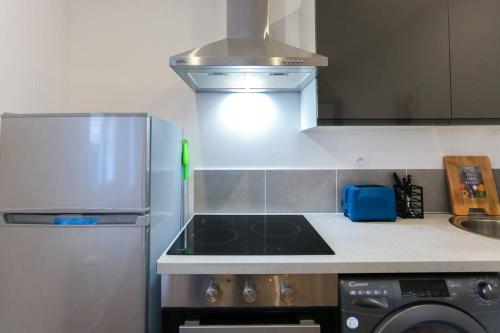 Il comprend une cuisine équipée d'une cuisinière. - un four supérieur à côté d'un réfrigérateur dans l'établissement L'hortentia T avec terrasse et salle de sport, à Amiens