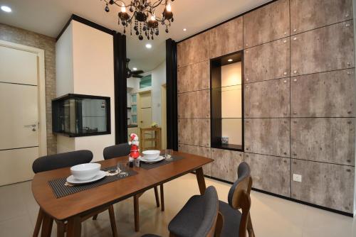 a dining room with a wooden table and chairs at 1Medini Theme Suite by Nest Home【LEGOLAND】 in Nusajaya