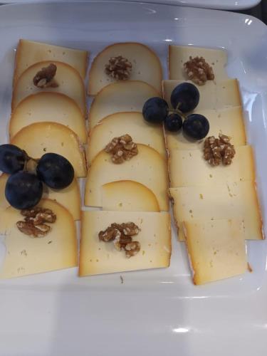 a plate of cheese with grapes and nuts on it at Hotel San Miguel Menorca in Mahón