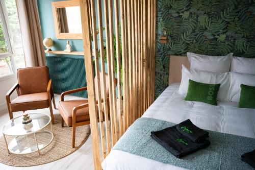 une chambre avec un lit et une chaise dans une pièce dans l'établissement LE PETIT LH - PLAGE - B'PAM, au Havre