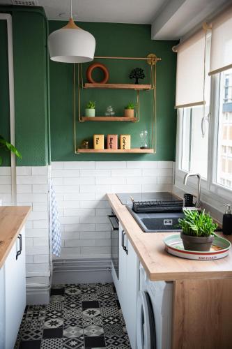 - une cuisine avec des murs verts et un comptoir dans l'établissement LE PETIT LH - PLAGE - B'PAM, au Havre