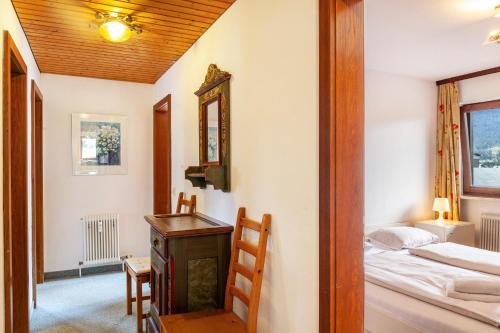 a bedroom with a bed and a desk and a mirror at Haus Excelsior Top 26/27 in Seefeld in Tirol
