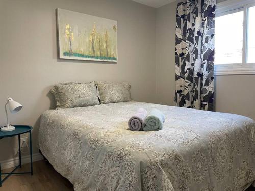 a bedroom with a bed with two towels on it at Spacious 3 bedroom apartment close Fairview! in Kitchener