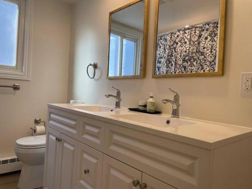 a bathroom with a sink and a toilet and a mirror at Spacious 3 bedroom apartment close Fairview! in Kitchener