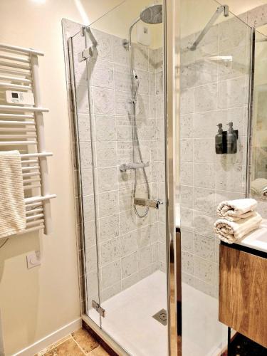 La salle de bains est pourvue d'une douche en verre. dans l'établissement Gîtes de charme - Gîtes VITAL, à Peyrus