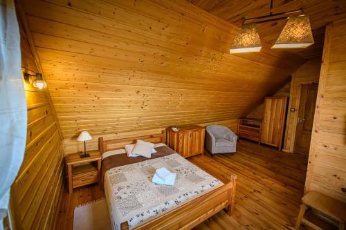 1 dormitorio con 1 cama en una cabaña de madera en Sokolisko - pensjonat agroturystyczny, en Wysoczany