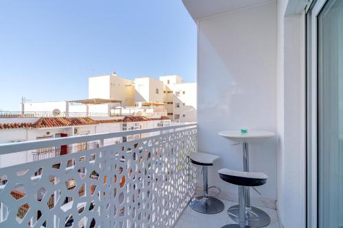 Balcón con mesa alta y celosía blanca