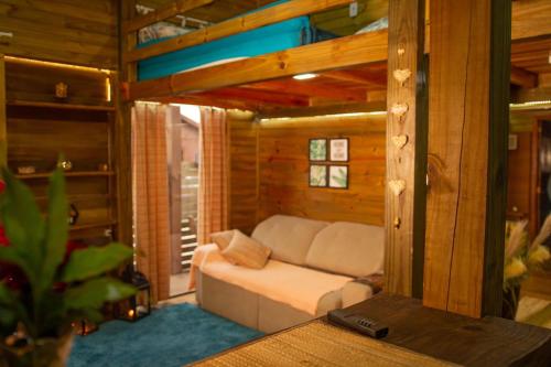 un soggiorno con divano in una casa di legno di cabanas Aconchego dos Canyons a Praia Grande