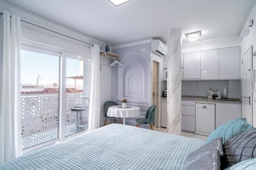 a bedroom with a bed and a kitchen with a balcony at Silver horizon Luxury apartment in Nerja
