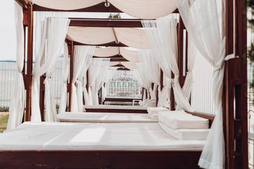 a canopy bed with white drapes in a room at 7 Lakes camping in Sapareva Banya