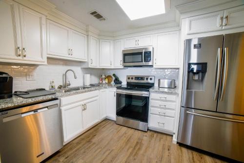 a kitchen with white cabinets and stainless steel appliances at Altitude Adjustment atop Sugar Mountain at Sugar Top in Sugar Mountain