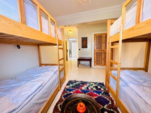 - 2 lits superposés dans une chambre avec un tapis dans l'établissement Locals Taghazout surfcamp, à Taghazout
