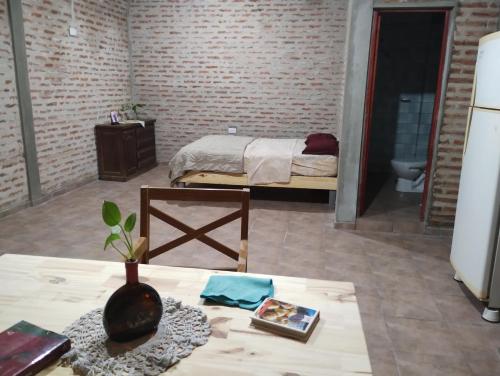 Un dormitorio con una cama y una mesa con un jarrón. en Departamento monoambiente en 