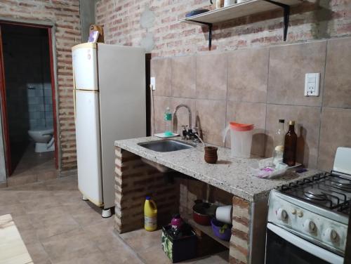 a kitchen with a white refrigerator and a sink at Departamento monoambiente in Roque Sáenz Peña