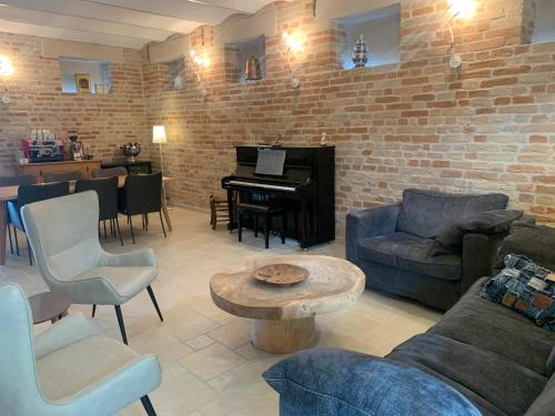 Una sala de estar con un sofá y un piano. en Gastronomic B&B CarloCarla, en Monte San Pietrangeli