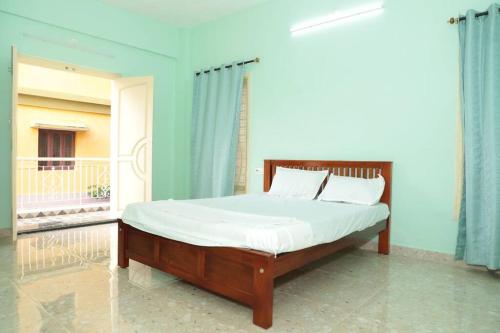 ein Schlafzimmer mit einem Bett mit einer weißen Tagesdecke in der Unterkunft Soundar villa in Puducherry