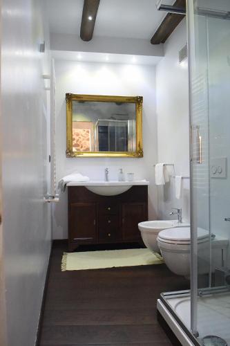 a bathroom with a sink and a toilet and a mirror at San Francesco Suite in Poggio Bustone