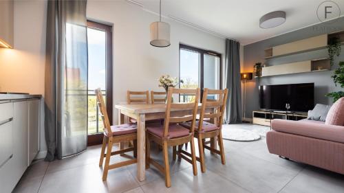 a kitchen and dining room with a table and chairs at City Center SPA Apartments Pool & Parking in Gdańsk