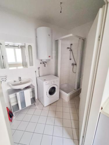 a bathroom with a washing machine and a sink at ADSA Apartments in Linz