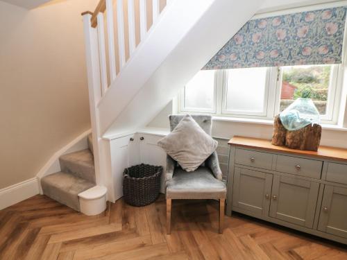 um quarto com escadas, uma cadeira e uma janela em Netherdale House em Buxton