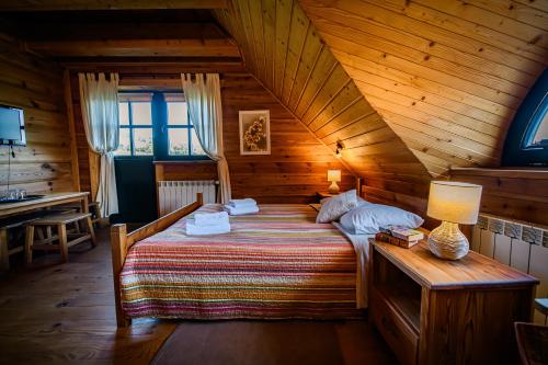 WysoczanyにあるSokolisko - pensjonat agroturystycznyの木造キャビン内のベッド1台が備わるベッドルーム1室を利用します。