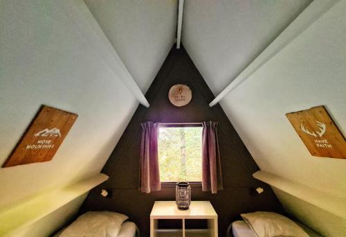 Cette petite chambre mansardée dispose d'une fenêtre et d'une table. dans l'établissement The Deer Lodge Durbuy, à Durbuy