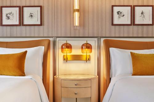 a bedroom with two beds and a lamp between them at St. Regis Aspen Resort in Aspen