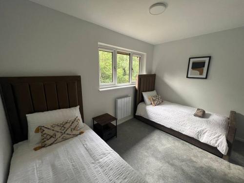 a bedroom with two beds and a window at Ideal 2 Bedroom Glasgow Home in Glasgow