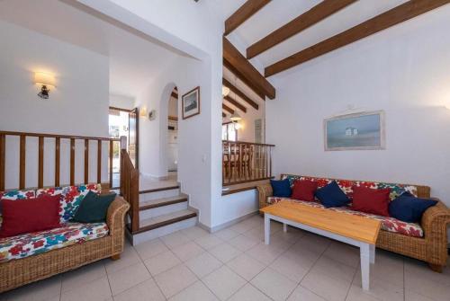 Una sala de estar con dos sofás y una escalera. en Villa Binibels, en Binibeca