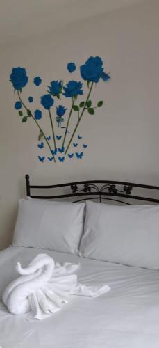 - une chambre avec un lit orné de fleurs bleues sur le mur dans l'établissement Richmond London 2 bed room Appartement, à Londres