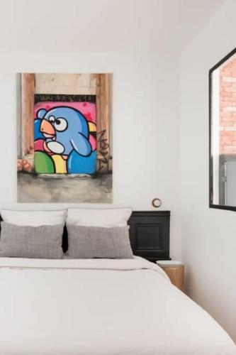 une chambre avec un lit avec un tableau sur le mur dans l'établissement Cabana & Appartement type Loft - Bellecour, à Lyon