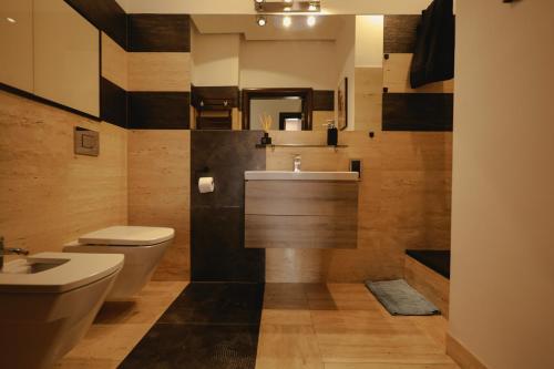a bathroom with a white toilet and a sink at Apartament w sercu Swinoujscia z 3 sypialniami in Świnoujście