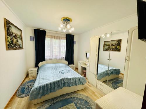 een slaapkamer met een bed en een spiegel bij Rodynnyi Zatyshok in Verkhovyna