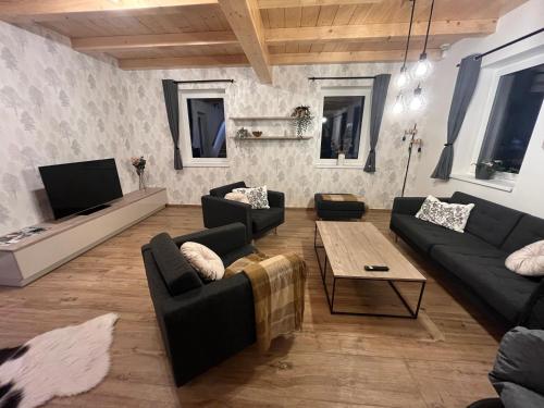 a living room with two couches and a tv at Chalupa pod Špičákem in Smržovka