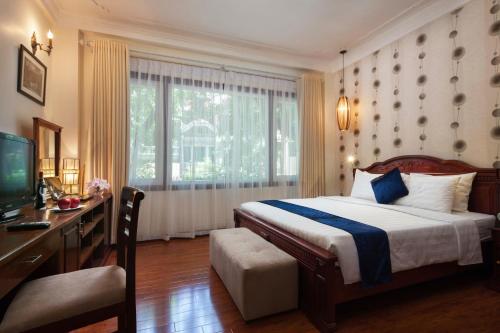 a bedroom with a bed and a desk and a television at Hanoi Golden Moon Hotel in Hanoi